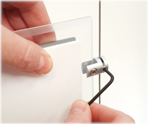 Using an Allen key to tighten the clamps screw to secure the pocket to a cable